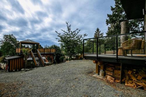 a tree house with a deck and a playground at 1-bedroom knotty Pine cabin w sauna & jacuzzi in Sooke