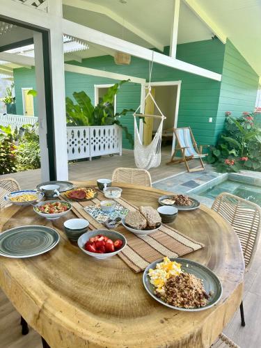 a wooden table with plates of food on it at Namaitamí Casa Hermosa con AC y piscina a Solo 650 Metros del Parque Nacional Cahuita in Cahuita