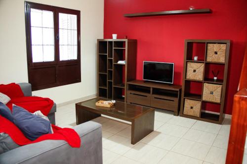een woonkamer met een bank en een tv bij Malvasía House in Costa Teguise