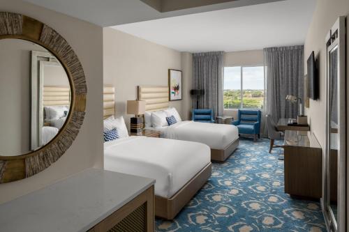 um quarto de hotel com duas camas e um espelho em The Karol Hotel, St. Petersburg Clearwater, a Tribute Portfolio Hotel em Clearwater