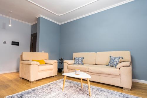 a living room with two couches and a table at Cane Apartment New Bazaar in Tirana