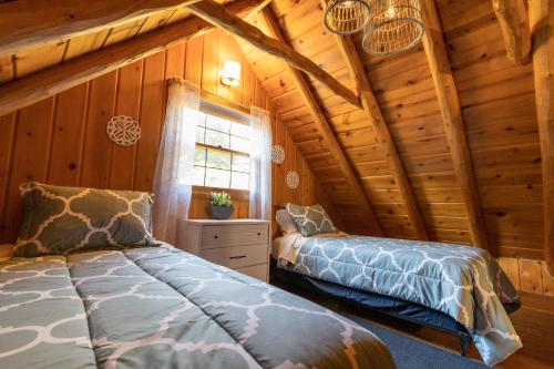 a bedroom with two beds in a log cabin at Athens and Albany's Hillside Haven in Albany