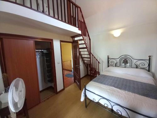 een slaapkamer met een bed en een wenteltrap bij SERRADO Da EIRA in Lajes das Flores