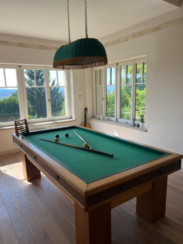 a billiard table in a room with windows at Vila Bellevue in Jablonec nad Nisou