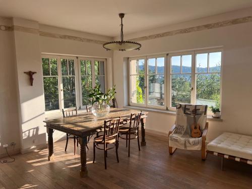 a dining room with a table and chairs and windows at Vila Bellevue in Jablonec nad Nisou