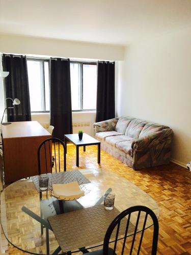 モントリオールにあるStylish Montreal Apartment: Comfortable Stay in the Golden Square Mileのリビングルーム(ソファ、テーブル付)