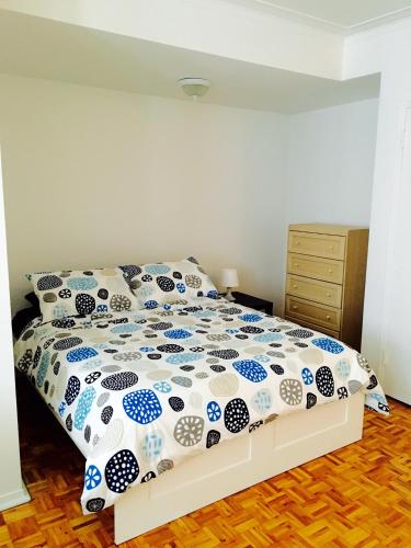 a bedroom with a bed with a blue and white comforter at Stylish Montreal Apartment: Comfortable Stay in the Golden Square Mile in Montreal