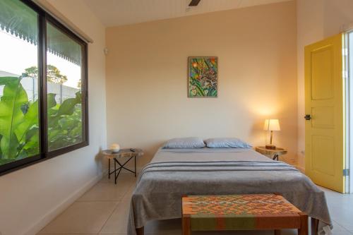 a bedroom with a bed and a large window at Namaitamí Casa Hermosa con AC y piscina a Solo 650 Metros del Parque Nacional Cahuita in Cahuita