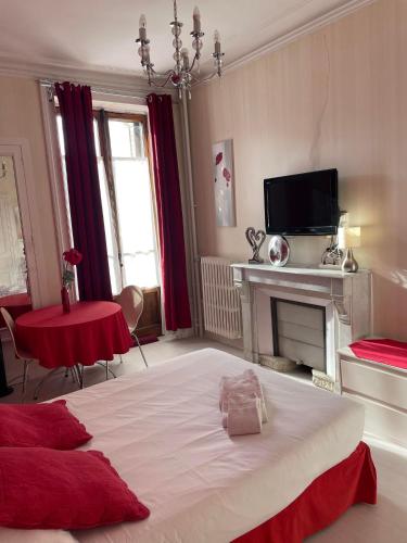 a bedroom with a large bed and a fireplace at Authentic by Balladins, Hôtel Le Carré d'Aix in Aix-les-Bains