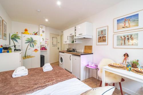 une cuisine avec des armoires blanches et une table dans une pièce dans l'établissement ExploreReims - Malibu beachhouse proche gare et centre, à Reims