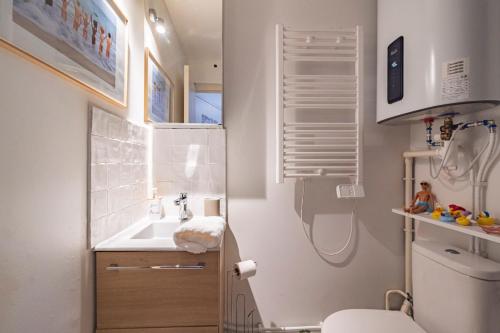 une petite salle de bain avec un lavabo et des toilettes dans l'établissement ExploreReims - Malibu beachhouse proche gare et centre, à Reims