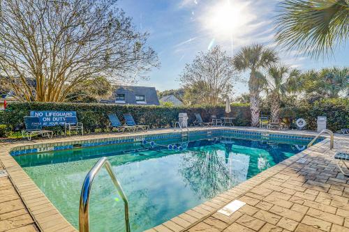 een zwembad met stoelen en een palmboom bij Queens Grant in Hilton Head Island