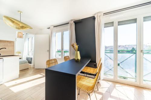 une cuisine et une salle à manger avec une table et des chaises dans l'établissement Le Cocon Margnolles - Caluire Croix Rousse, à Caluire-et-Cuire