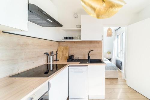 une cuisine avec des armoires blanches et un évier dans l'établissement Le Cocon Margnolles - Caluire Croix Rousse, à Caluire-et-Cuire