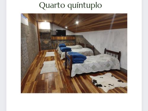 a group of four beds in a room at Flats Brancas Nuvens in Campos do Jordão