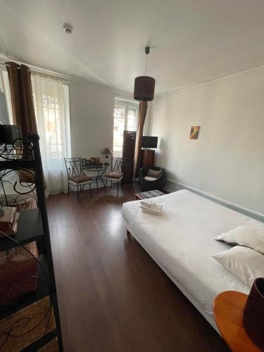 a bedroom with a bed and a table and chairs at Authentic by Balladins, Hôtel Le Carré d'Aix in Aix-les-Bains