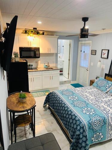 a bedroom with a bed and a table and a kitchen at Lovely rental unit with independent entrance apt # 1 in Tampa