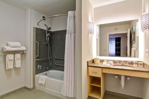 a bathroom with a tub and a shower and a sink at Homewood Suites by Hilton Stratford in Stratford