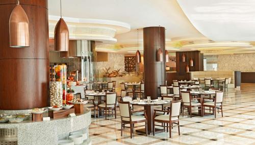 a restaurant with tables and chairs in a room at Waldorf Astoria Dubai Palm Jumeirah in Dubai