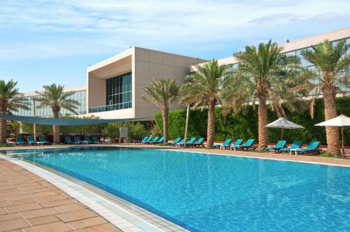 a swimming pool in front of a resort at Hilton Kuwait Resort in Kuwait