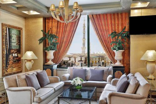 a living room with couches and a large window at Madinah Hilton Hotel in Al Madinah