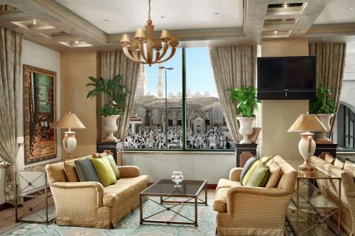 a living room with two couches and a tv at Madinah Hilton Hotel in Al Madinah