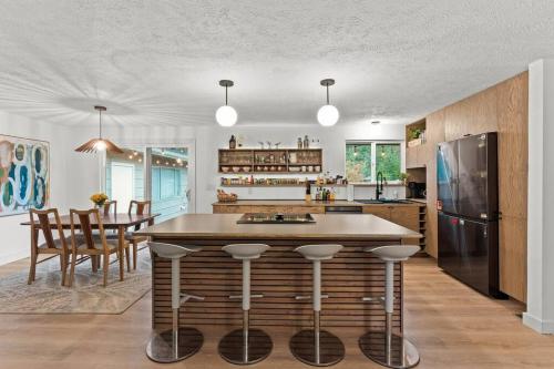 a kitchen with a large island with bar stools at Hot Tub Blackstone Fire Pit Ping Pong River in Nine Mile Falls