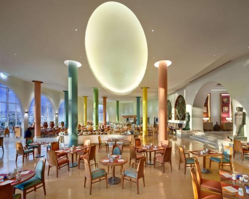 a restaurant with tables and chairs and a large orb at Hilton Marsa Alam Nubian Resort in Abu Dabab