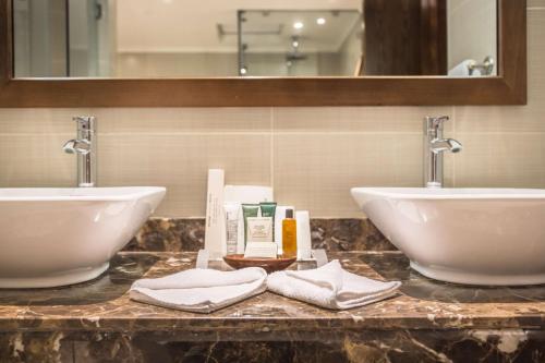 a bathroom with two sinks and towels on a counter at Hilton Marsa Alam Nubian Resort in Abu Dabab