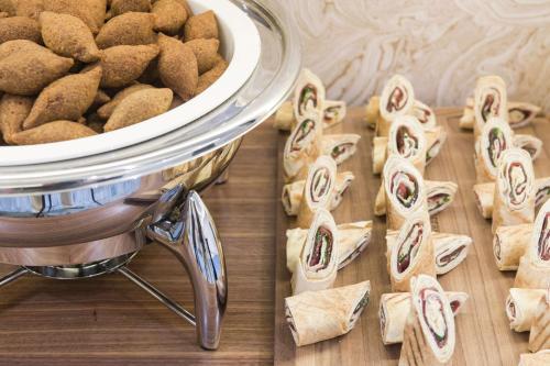 a pile of cookies on a table next to a bowl of food at Hilton Garden Inn Ras Al Khaimah in Ras al Khaimah