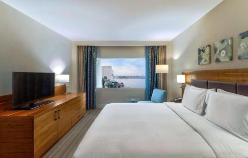 a hotel room with a large bed and a television at Hilton Garden Inn Ras Al Khaimah in Ras al Khaimah