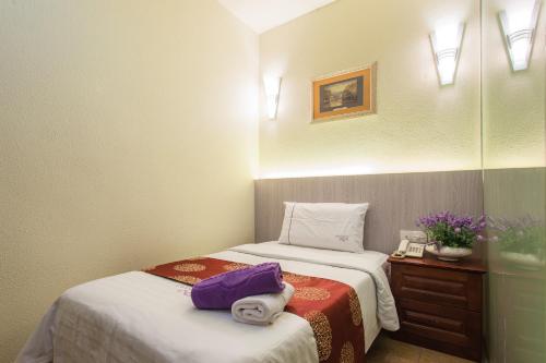 a room with two beds with towels and a telephone at Lavender Inn Permas Jaya in Johor Bahru