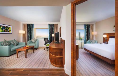 拉斯海瑪的住宿－希爾頓哈伊馬角酒店，配有一张床和一张书桌的酒店客房
