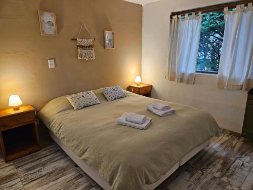 a bedroom with a bed with two towels on it at Las Adelas Chaltén in El Chalten
