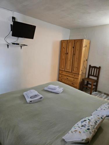 - une chambre avec un lit et une télévision murale dans l'établissement Las Adelas Chaltén, à El Chalten