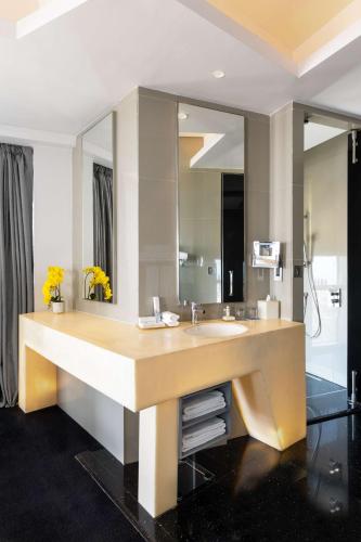 a bathroom with a large sink and a mirror at V Hotel Dubai, Curio Collection by Hilton in Dubai