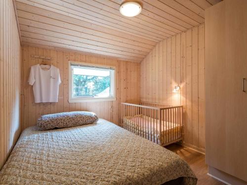 a small bedroom with a bed and a window at Holiday home Nørre Nebel III in Nørre Nebel