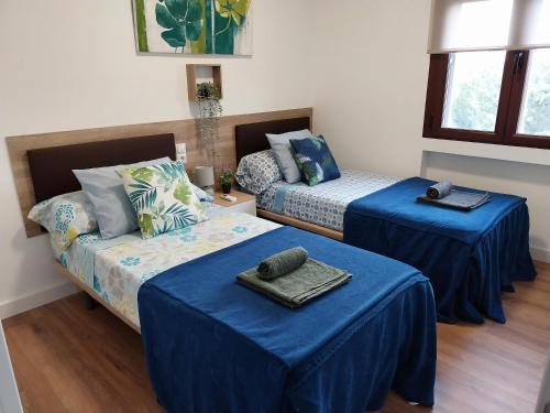 Navas de San AntonioにあるPISO NAVAS 2のベッド2台、ソファ(青いシーツ付)が備わる客室です。