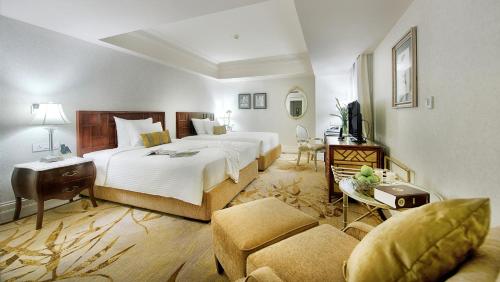 a hotel room with a large bed and a couch at Apricot Hotel in Hanoi