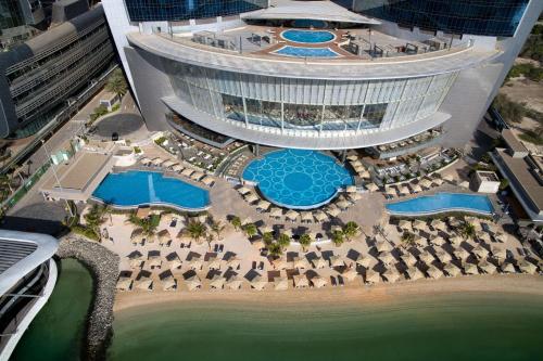 an aerial view of a resort with pools and a building at Conrad Abu Dhabi Etihad Towers in Abu Dhabi
