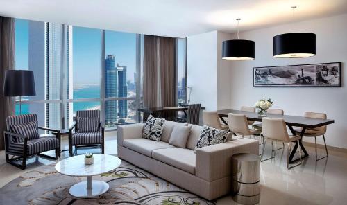 a living room with a couch and a table and a dining room at Conrad Abu Dhabi Etihad Towers in Abu Dhabi