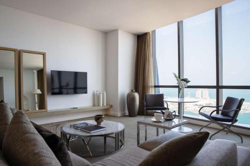 a living room with a couch and a tv at Conrad Abu Dhabi Etihad Towers in Abu Dhabi