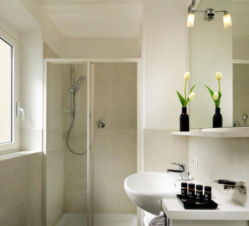 a white bathroom with a shower and a sink at Villa delle Palme in Santa Marinella