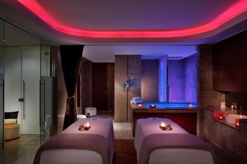 a room with four beds and a pool table at Conrad Abu Dhabi Etihad Towers in Abu Dhabi