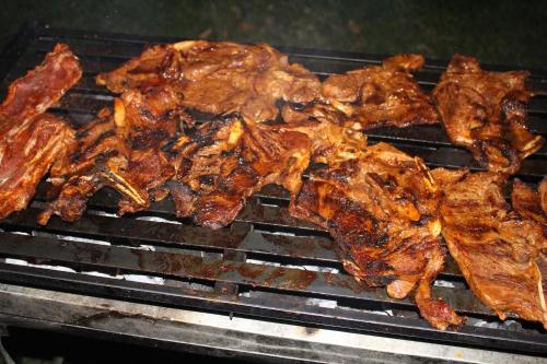 a bunch of meat cooking on a grill at Oasis Paraiso Ecolodge in Cabanaconde