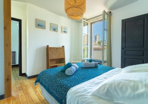 Un dormitorio con una cama grande con almohadas azules. en Le Cordelier - Jardin en plein centre - Quais de Seine, en Troyes