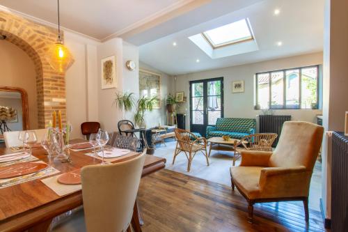 une salle à manger et un salon avec une table et des chaises dans l'établissement Le Cordelier - Jardin en plein centre - Quais de Seine, à Troyes