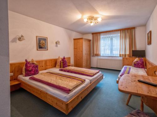 a hotel room with two beds and a television at Oberleitner XL in Brixen im Thale