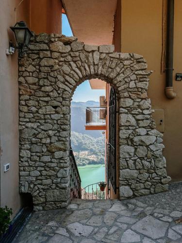 an arch in a stone wall with a view of a lake at Lago del Turano - La Taverna con cucina open space e free WI-FI in Ascrea