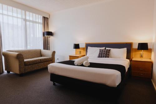 a hotel room with a bed and a chair at Comfort Inn Traralgon in Traralgon